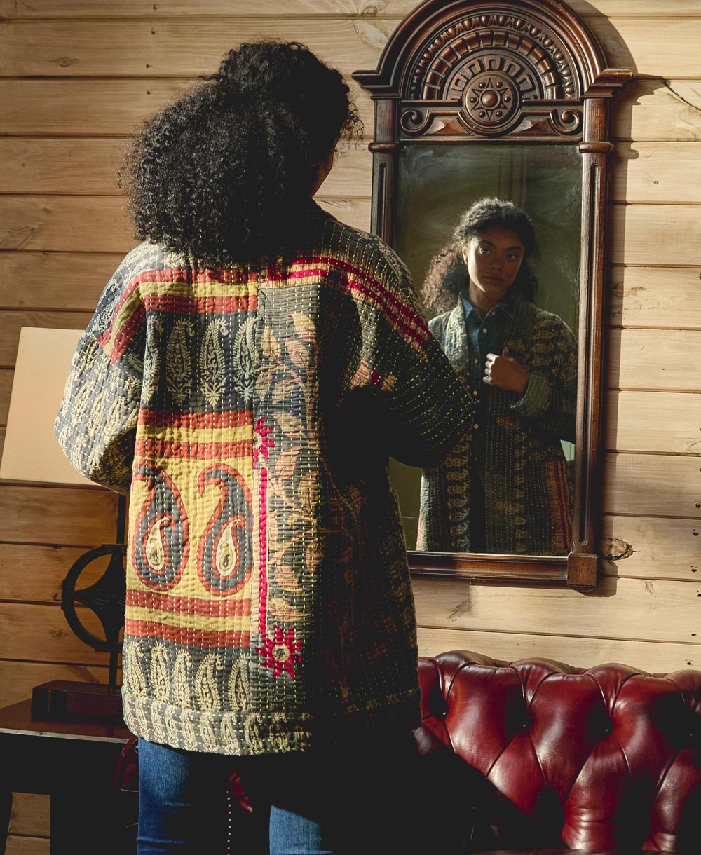 woman wearing kantha quilted jacket looking in the mirror