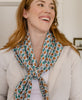 woman smiling while wearing an Anchal vintage kantha square scarf tied around her shoulders