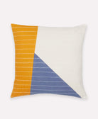 Decorative pillow with mustard yellow, blue, and white color block design on a white background