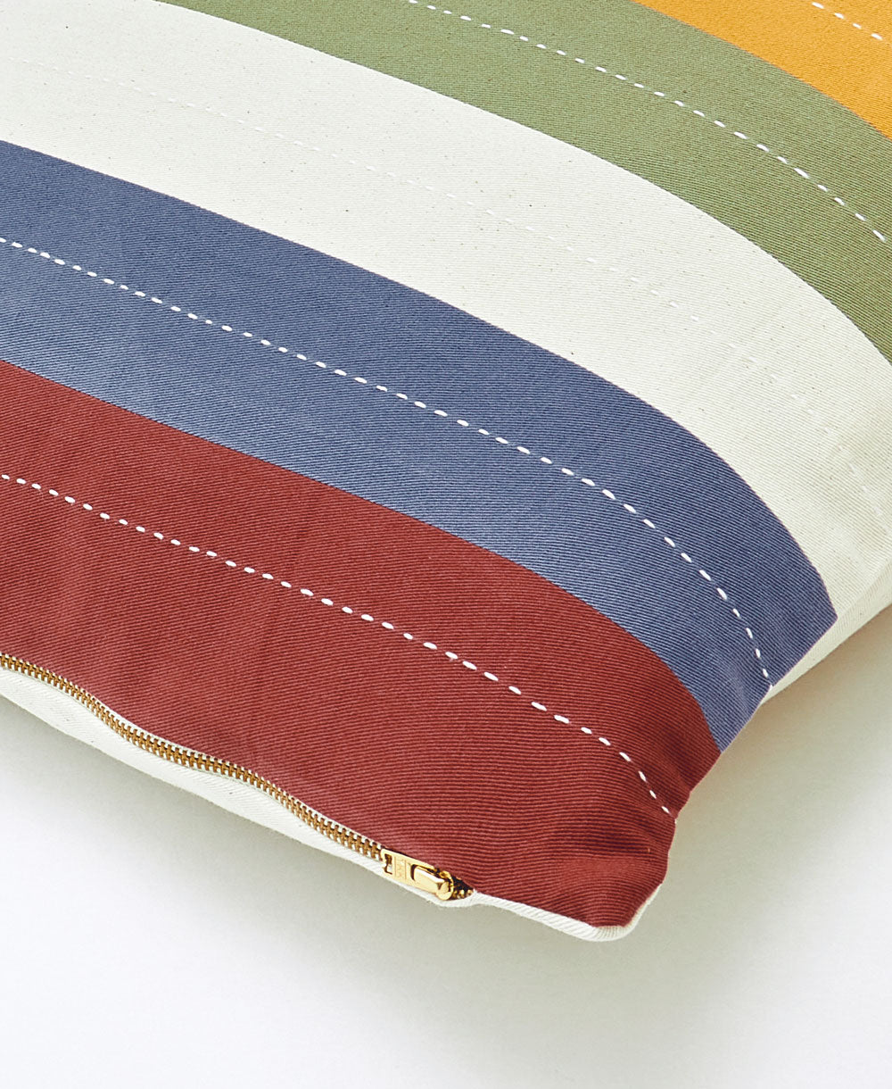 Colorful striped pillow with a gold zipper on a white background