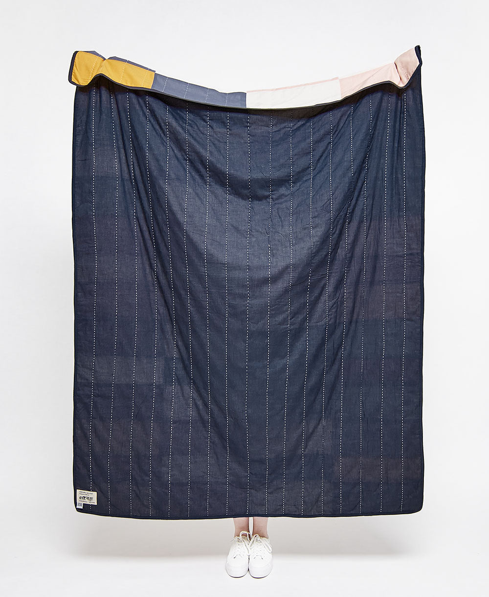 back of multi-check patchwork quilt in solid navy with white embroidery