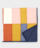 Colorful quilt with geometric pattern on a light gray background