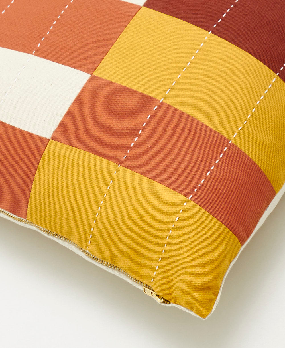 Checkered pillow with red and yellow blocks on a white background