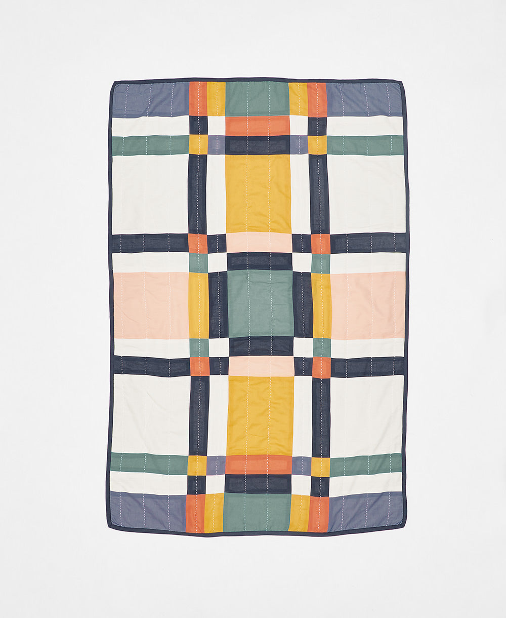 Multicolored checkered quilt blanket on a white background
