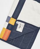 artisan-signed brand tag on multi-plaid baby quilt handmade in India