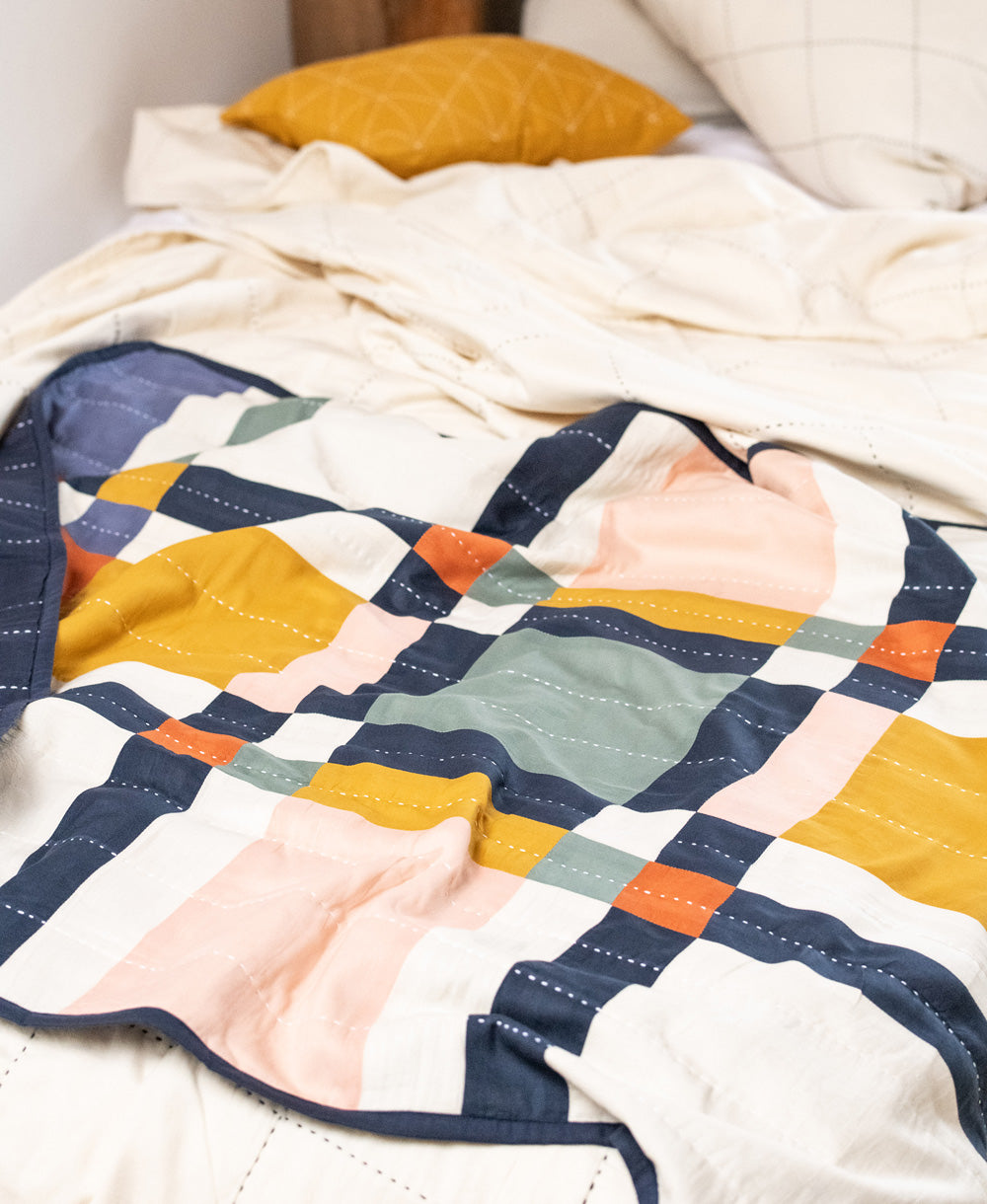 Colorful quilt with geometric pattern on a bed