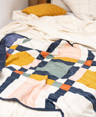 Colorful quilt with geometric pattern on a bed