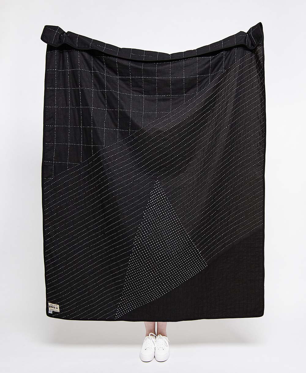 modern black kantha quilt with geometric white stitching