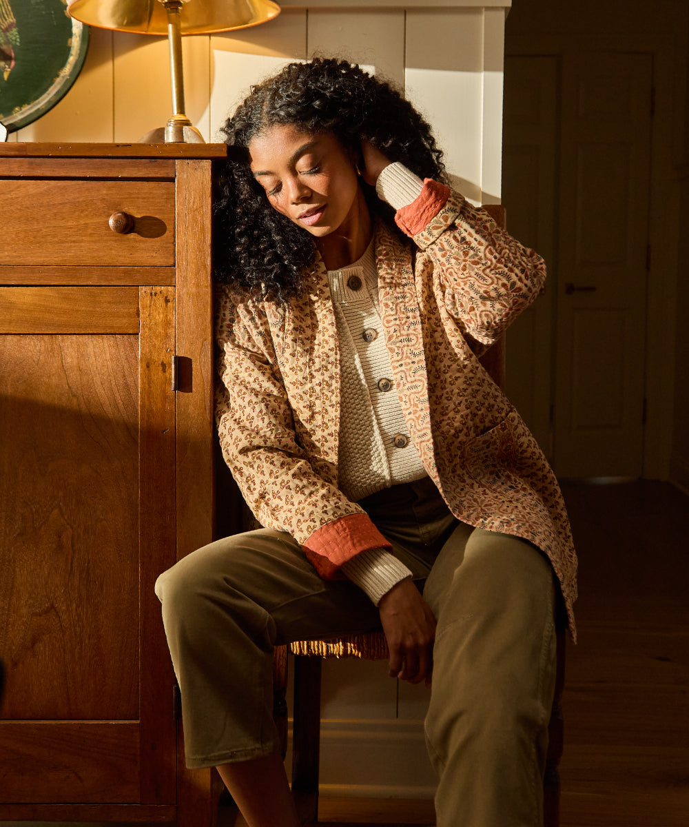 woman wearing vintage kantha jacket sitting on wooden chair