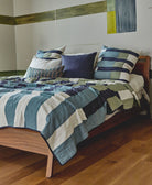 Bed with a patchwork quilt and pillows in a bedroom setting
