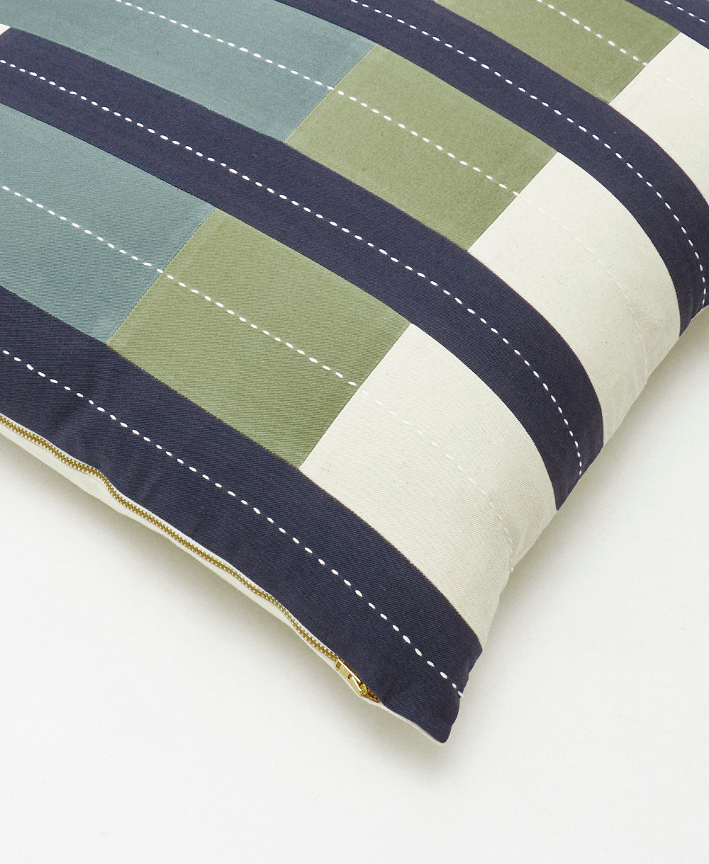close up of offset throw pillow with brass YKK metal zipper closure