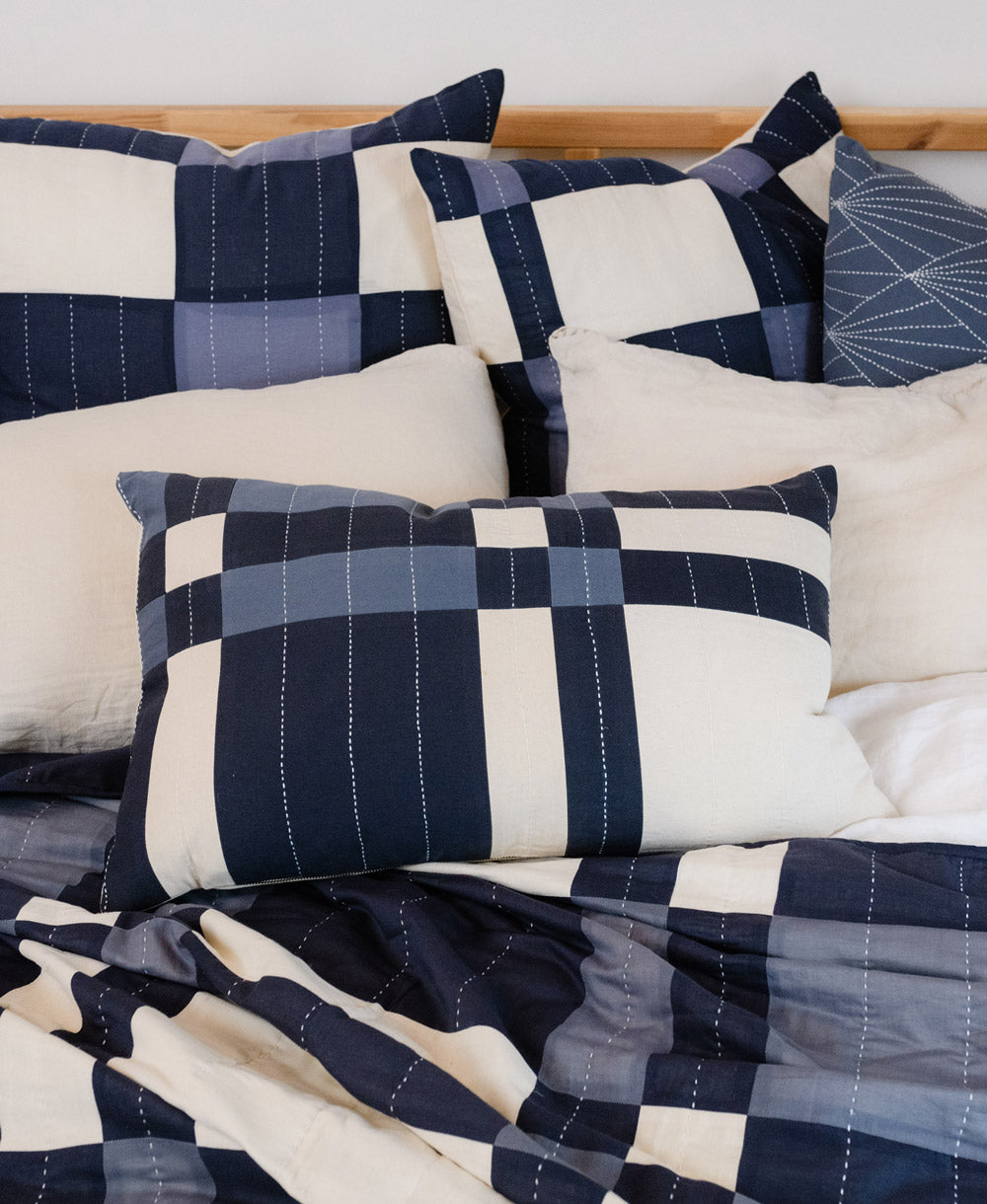 Bed with navy and white checkered bedding and pillows