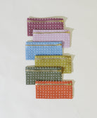 Set of six polka dot pouches in various colors on a light gray background