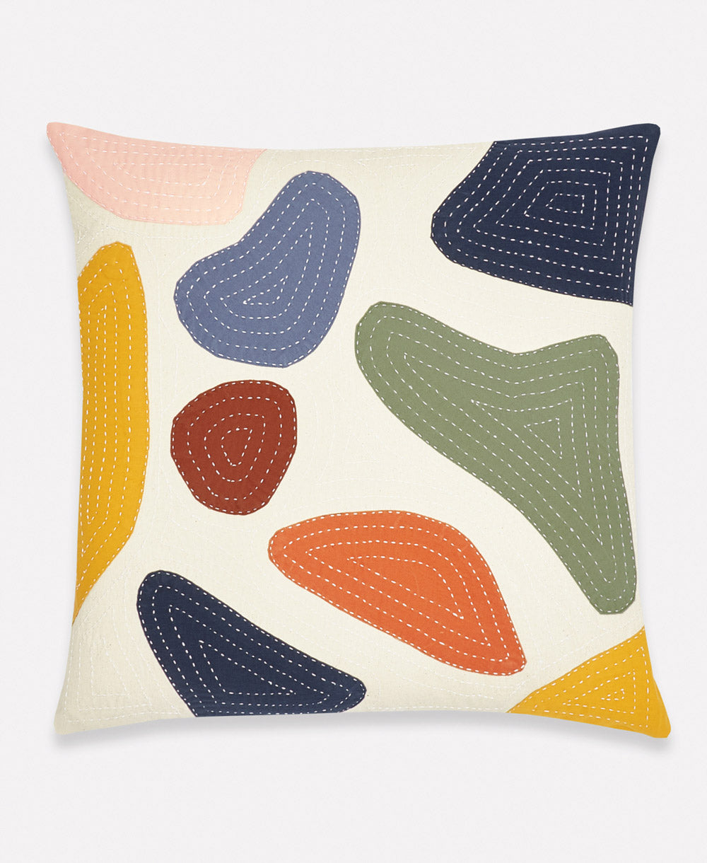 Decorative pillow with colorful abstract shapes on a beige background