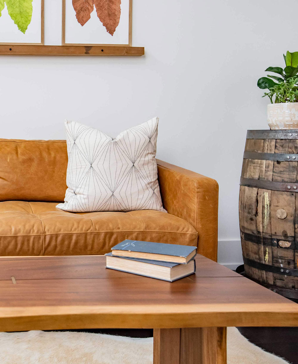 prism modern throw pillow in white sittin on camel brown leather sofa with wooden coffee table