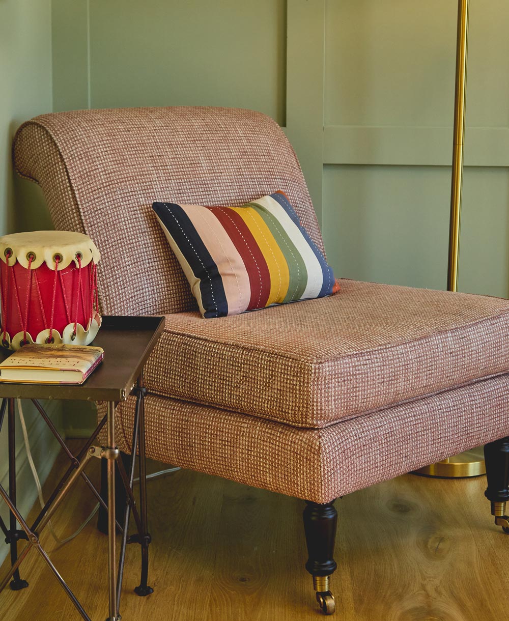Patterned armchair with a colorful pillow in a room setting
