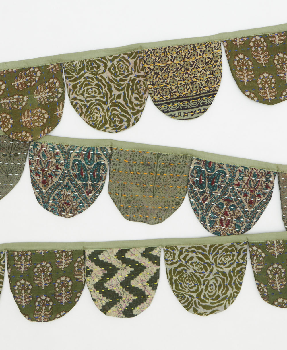 Decorative fabric border with green and brown patterns on a white background