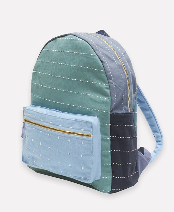 Teal, light blue, and navy back pack with horizontal stitching and small cross design