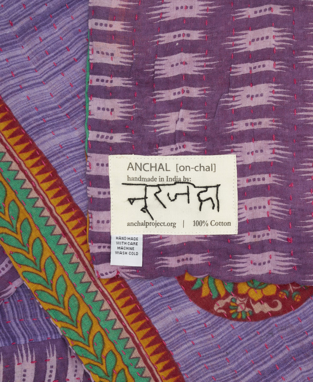 small kantha blanket with signature of the artisan maker on the tag