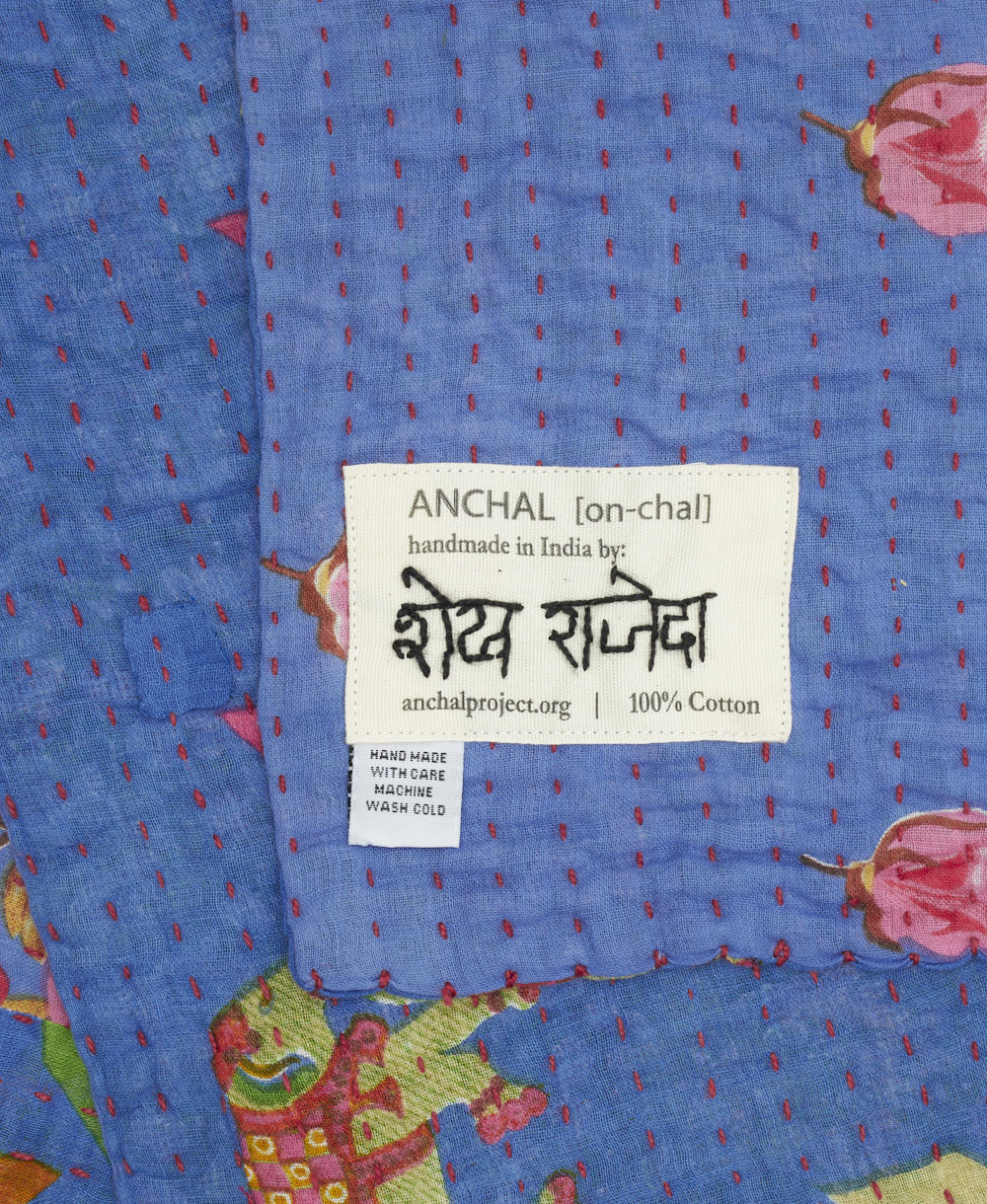 small kantha blanket with signature of the artisan maker on the tag