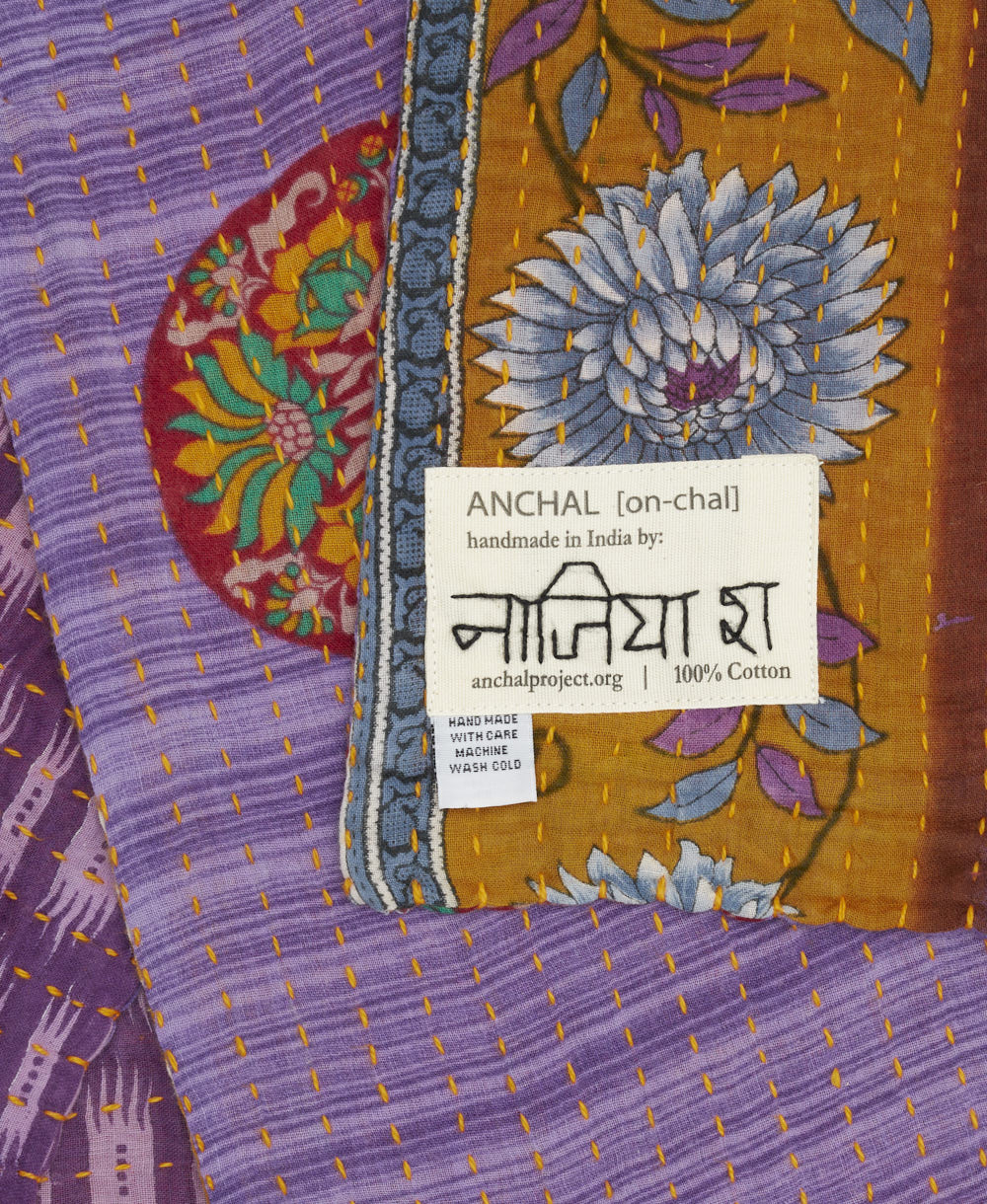 small kantha blanket with signature of the artisan maker on the tag