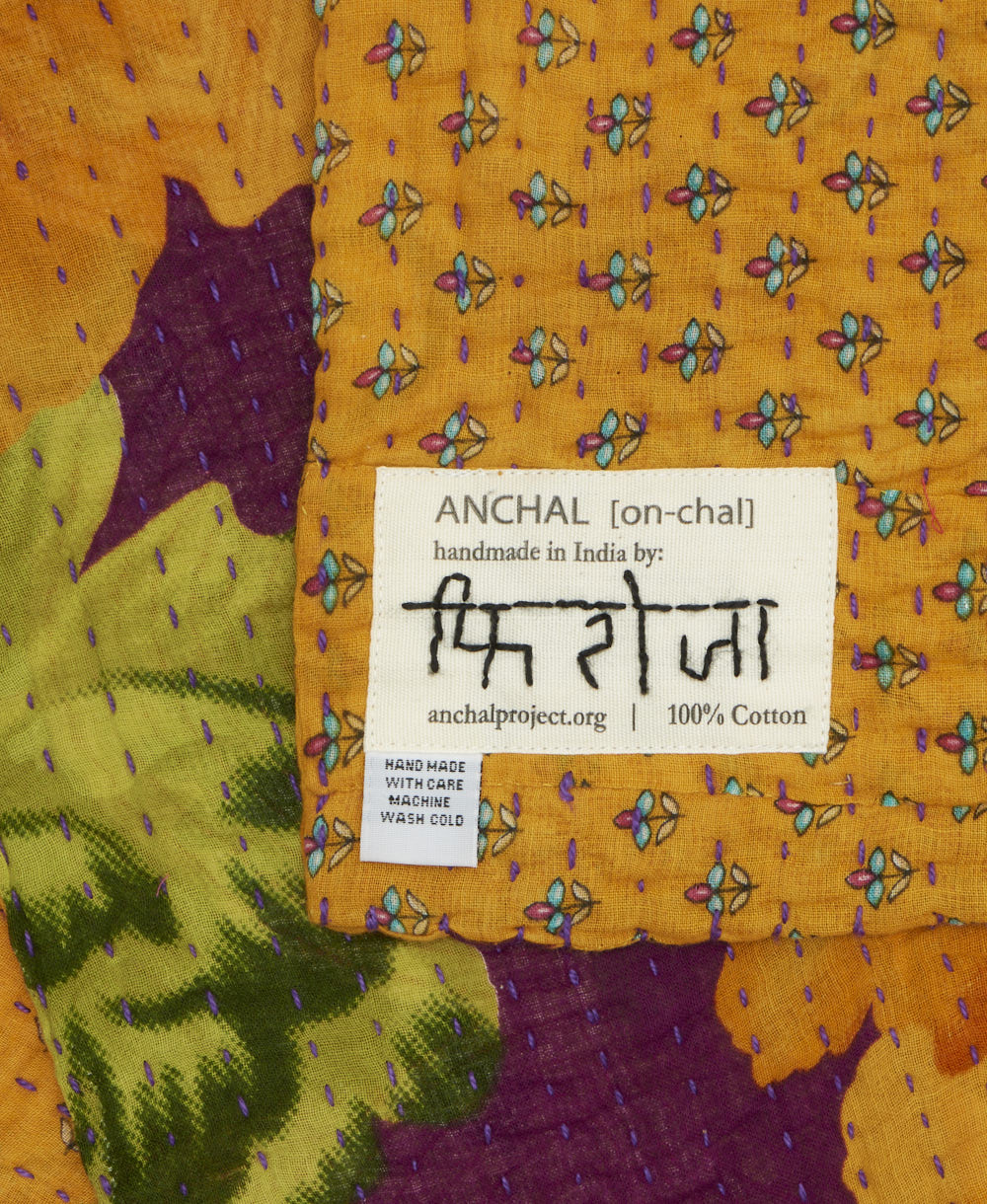 small kantha blanket with signature of the maker on the tag
