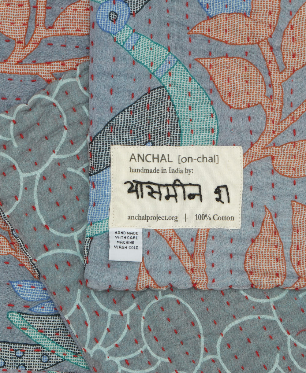 small kantha blanket with signature of the maker on the tag