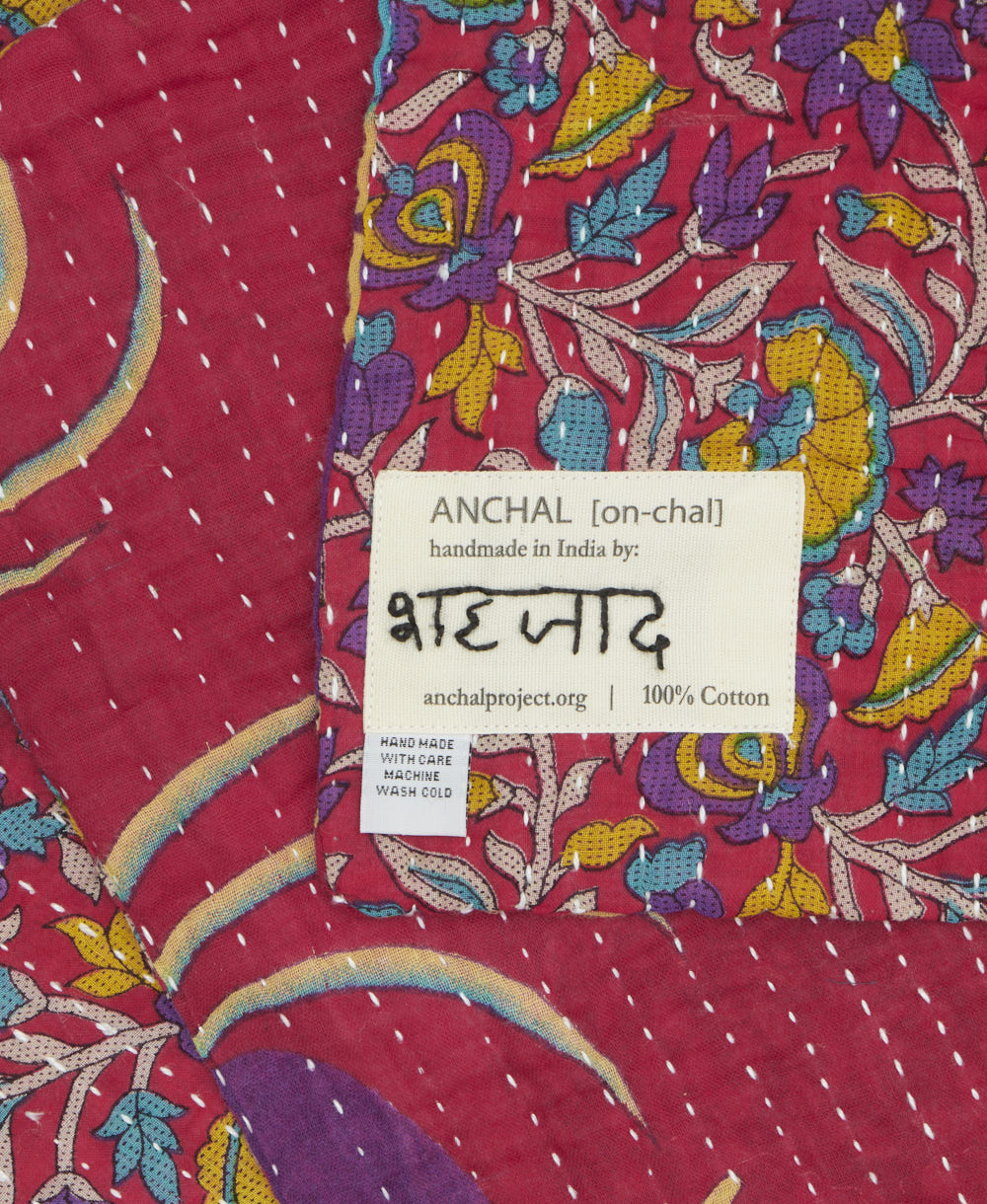 small kantha blanket with signature of the maker on the tag