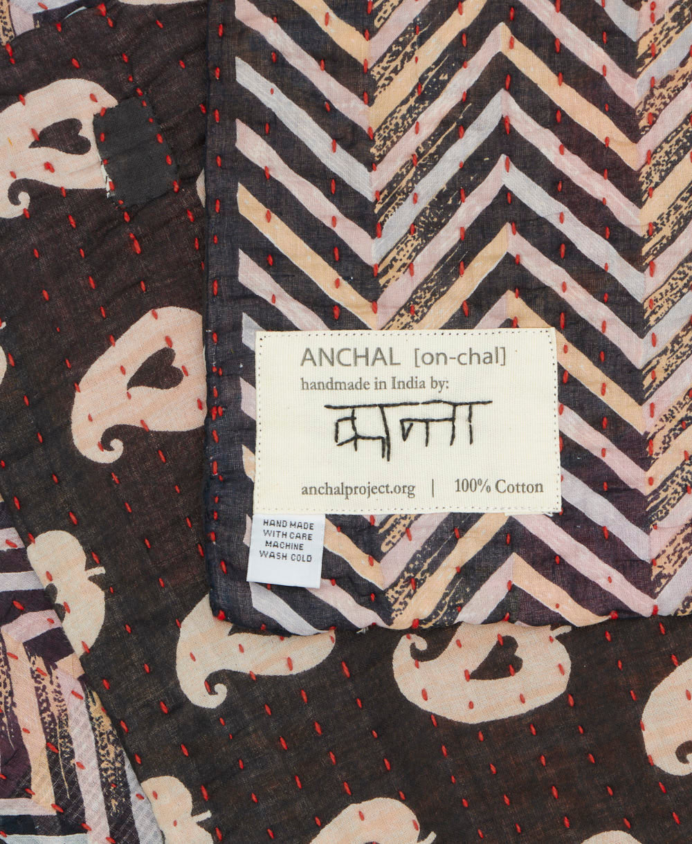 small kantha blanket with signature of the maker on the tag