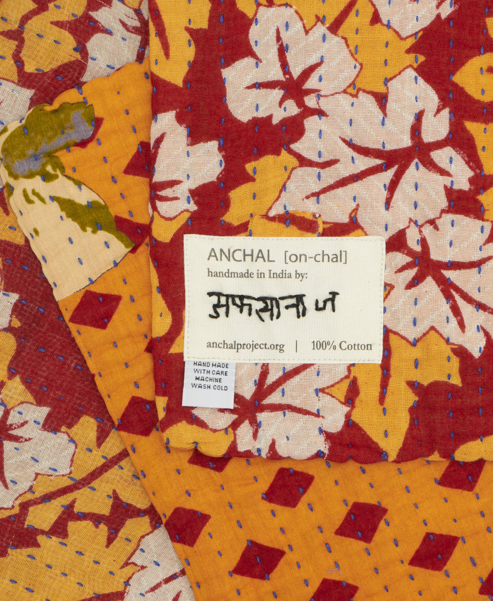 small kantha blanket with signature of the maker on the tag