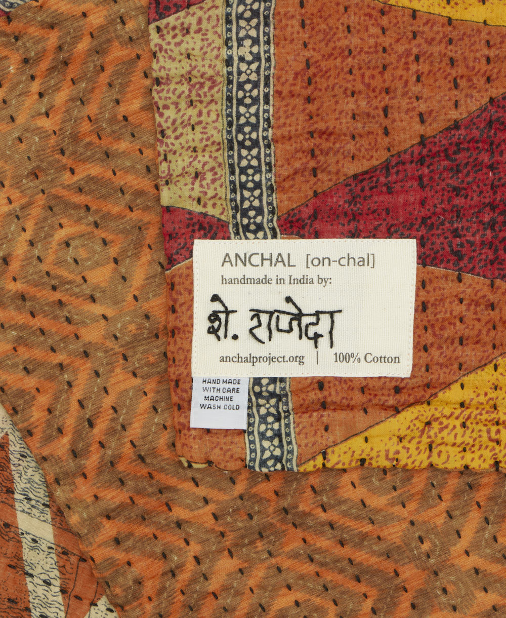 small kantha blanket with signature of the maker on the tag