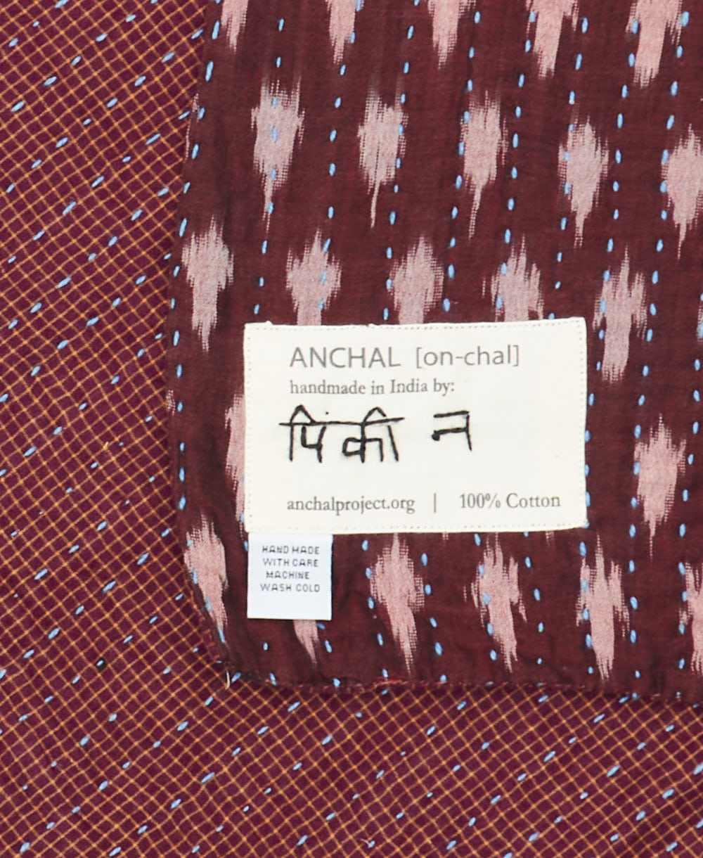 small kantha blanket with signature of the maker on the tag