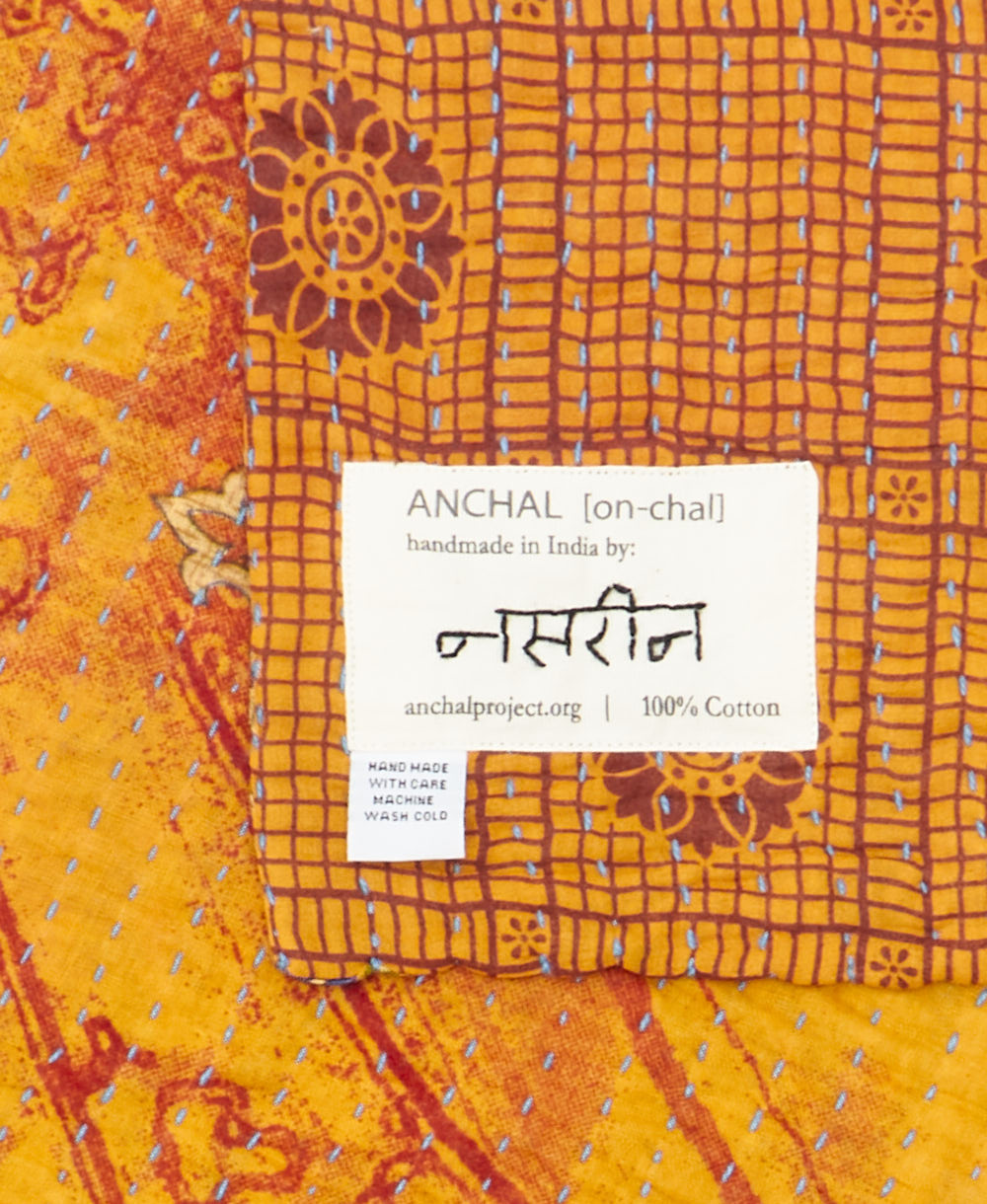 small kantha blanket with signature of the maker on the tag