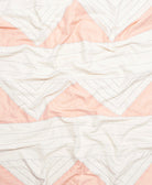 Close-up of a quilt with pink and white chevron pattern