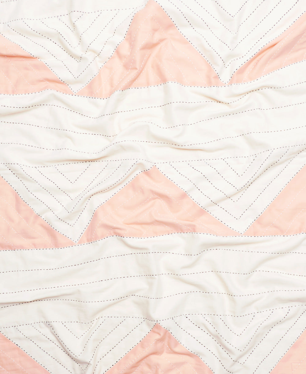 Close-up of a quilt with pink and white chevron pattern