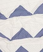 Close-up of a quilt with blue and white chevron pattern
