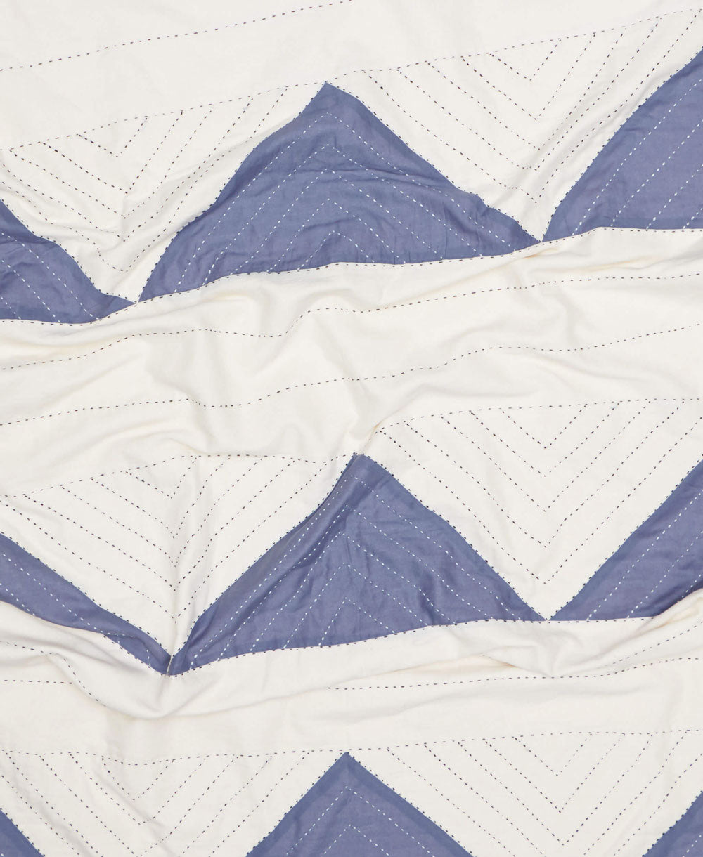 Close-up of a quilt with blue and white chevron pattern