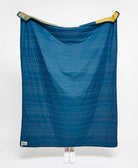 Blue quilt with white stitching on a white background