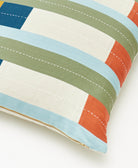 Close-up of a striped pillow with blue, green, and orange colors on a white background