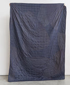 Navy quilt with geometric pattern on a white background