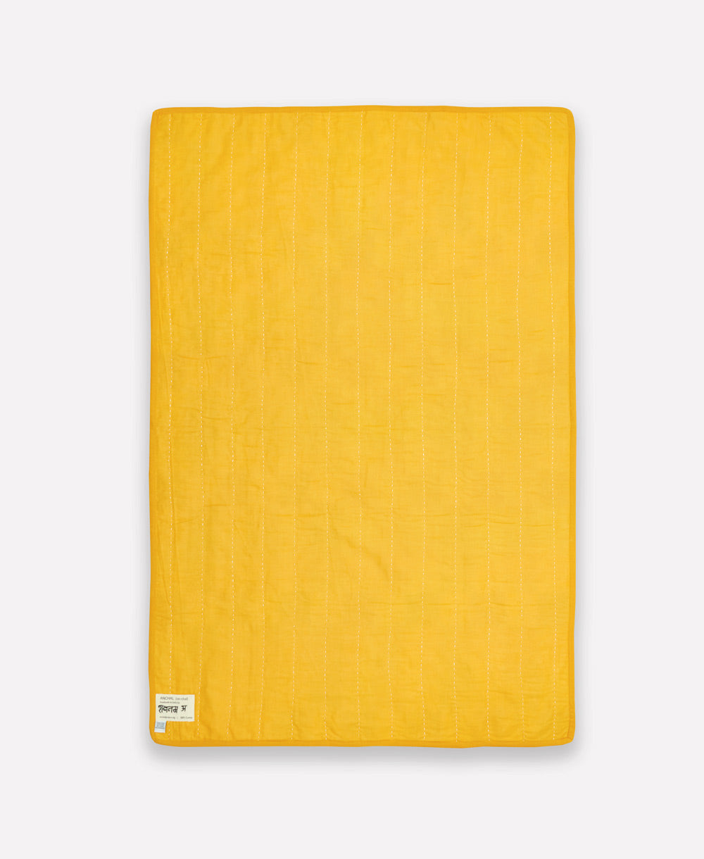 back of tile baby quilt in solid mustard yellow