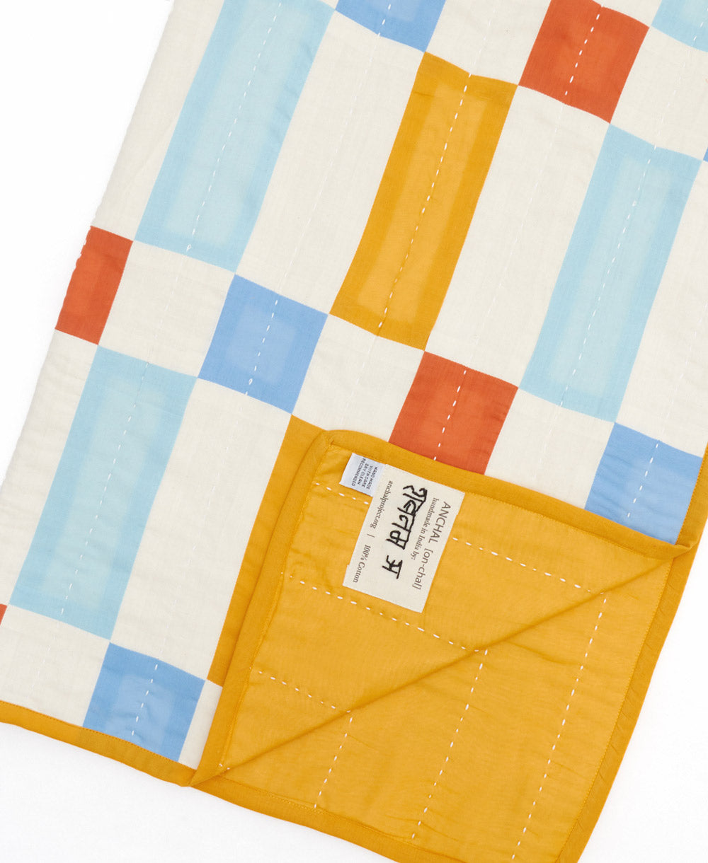 artisan made baby quilt with their name hand-stitched on the product tag