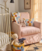 Children's room with pink chair, teddy bears, and colorful blanket