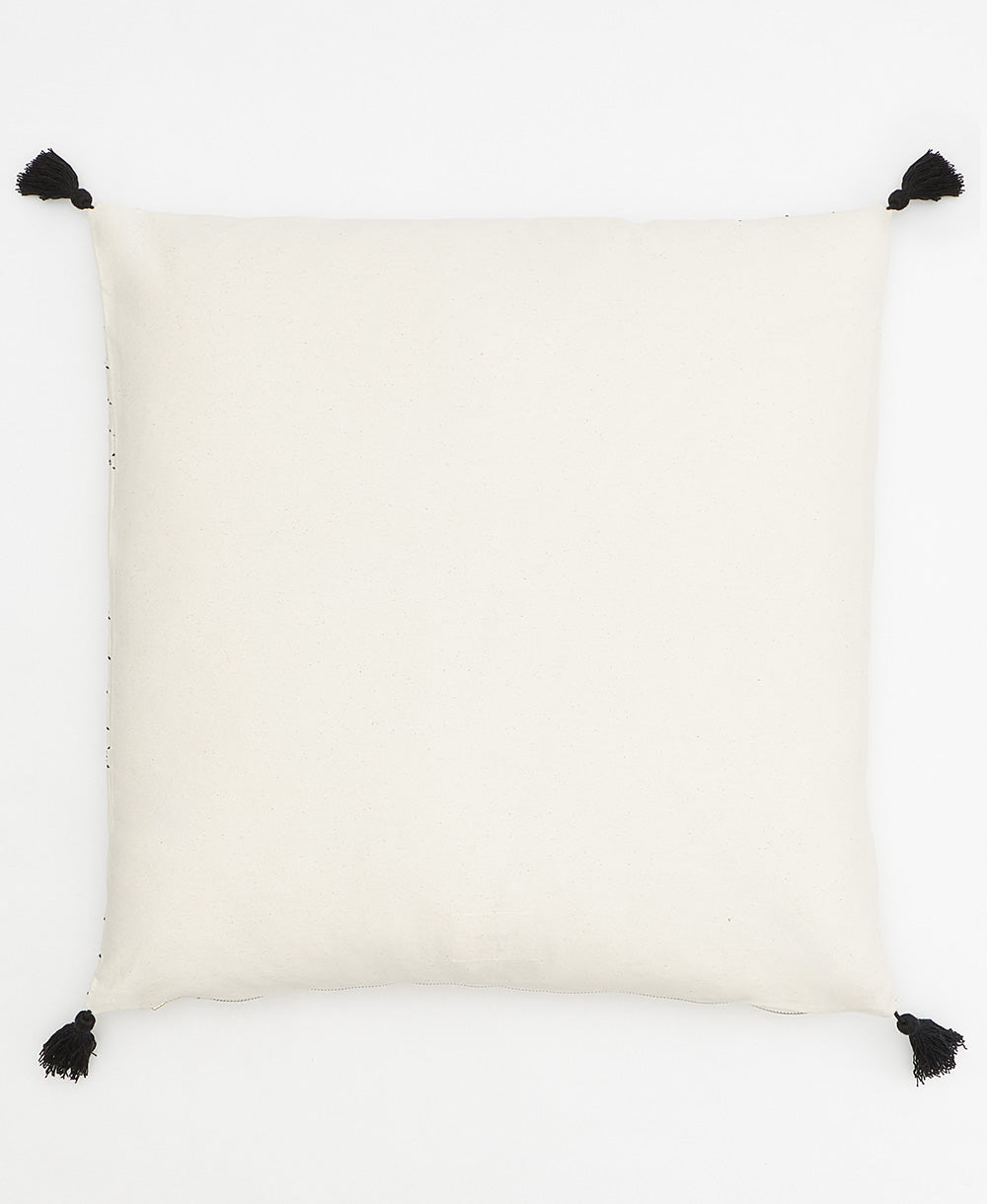 back of tilt throw pillow in bone with black tassels