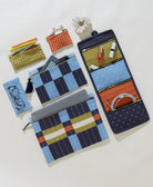 Set of fabric pouches with different designs and compartments on a light background