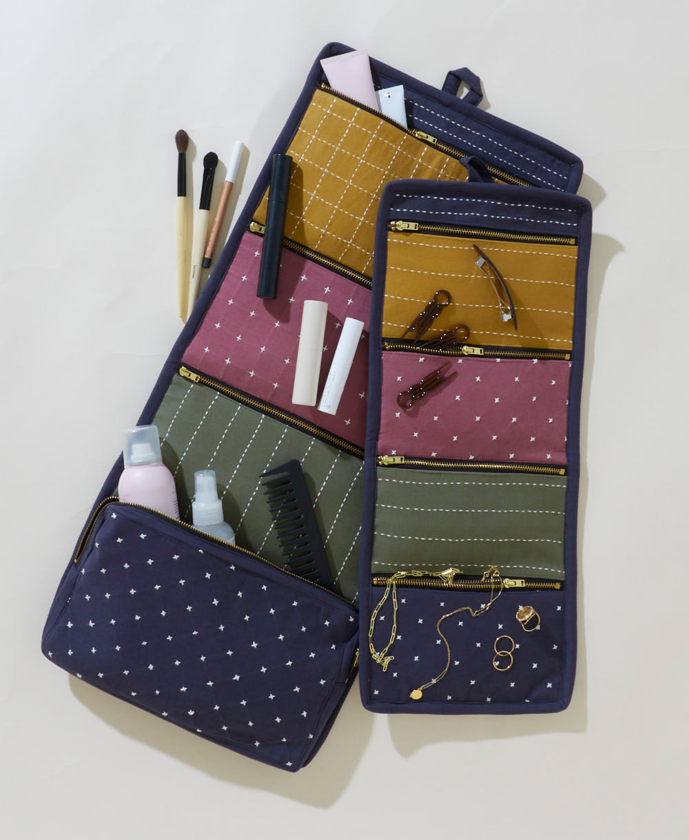 Navy blue makeup bag with various cosmetic items on a light background