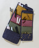 Navy blue makeup bag with various cosmetic items on a light background