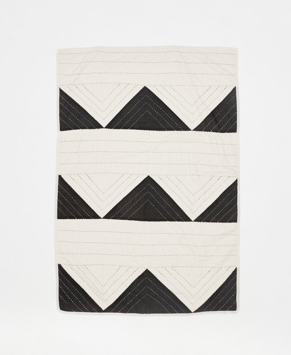 Quilt with black and white chevron pattern on a white background