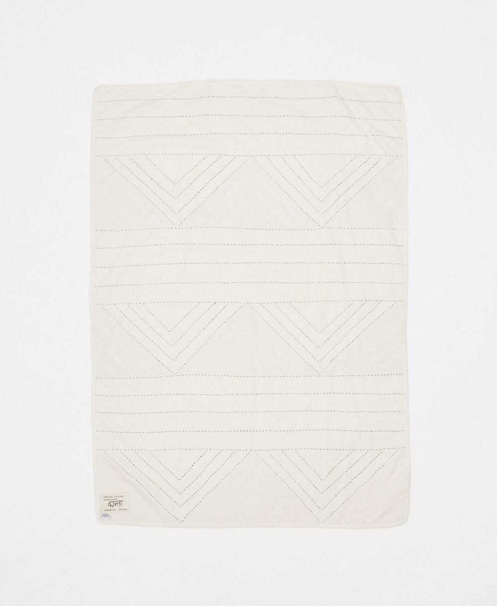 White textured blanket with geometric pattern on a white background