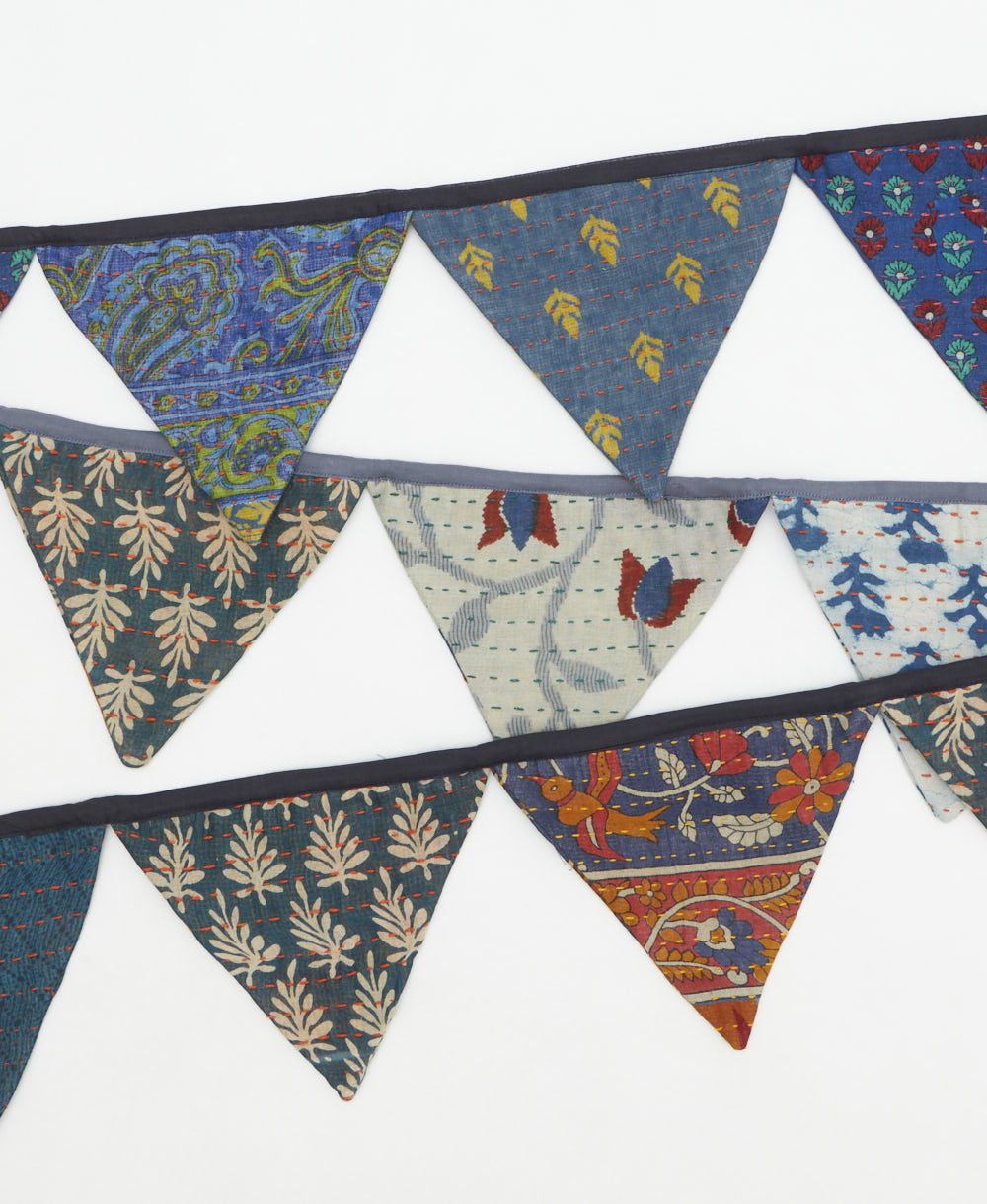 Colorful fabric triangle banner with various patterns on a white background